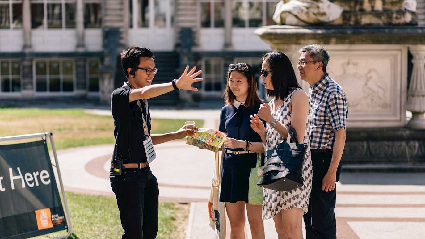 people taking directions from a staff member on a campus tour - book a campus tour