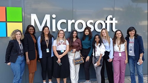A photograph of students on field study trip in front of Microsoft logo